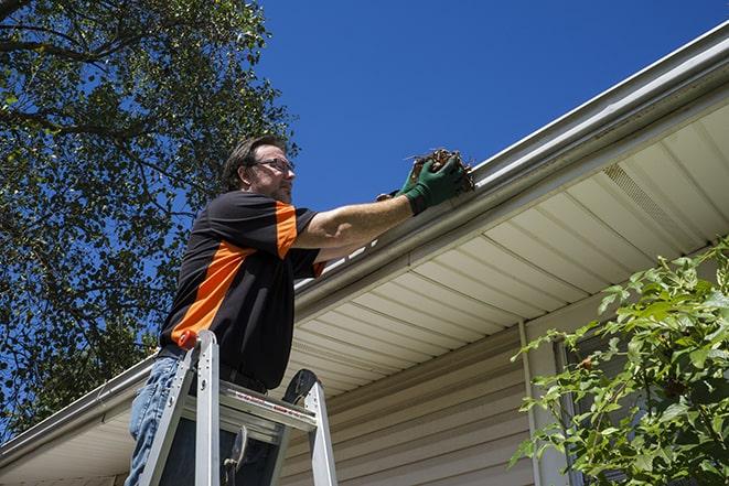 worker repairing a leak in a residential gutter in Bell